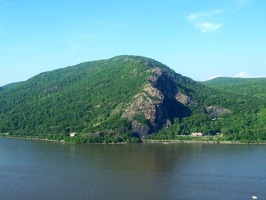 Hikers scrambling up the exposed rock of Breakneck Ridge above the Hudson River