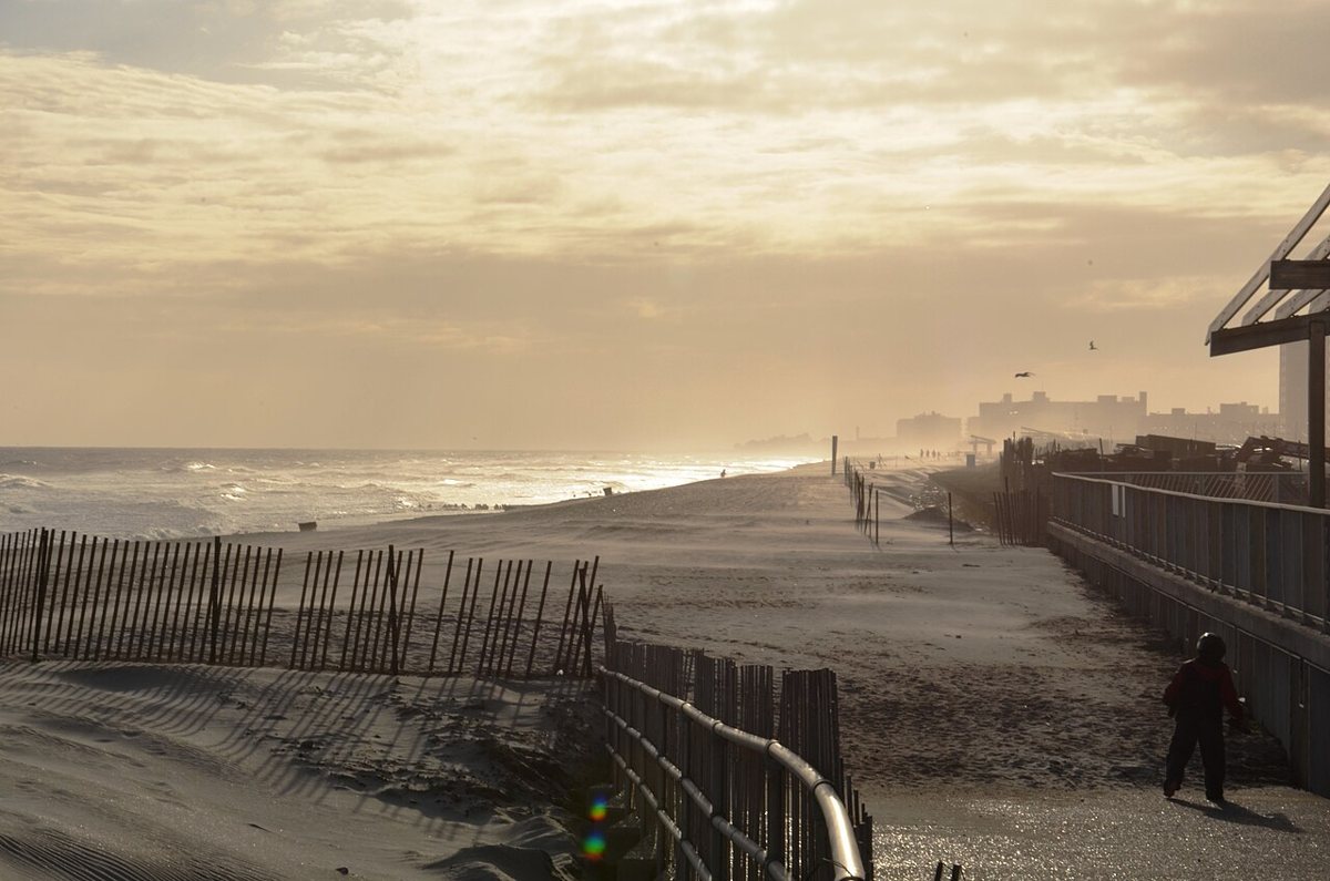 Surfers and beachgoers on the sand at Rockaway Beach in Queens, New York