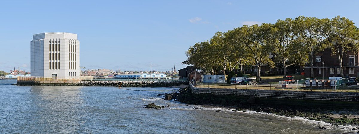 Visitors relaxing on the lawn with the Manhattan skyline behind Governors Island, New York