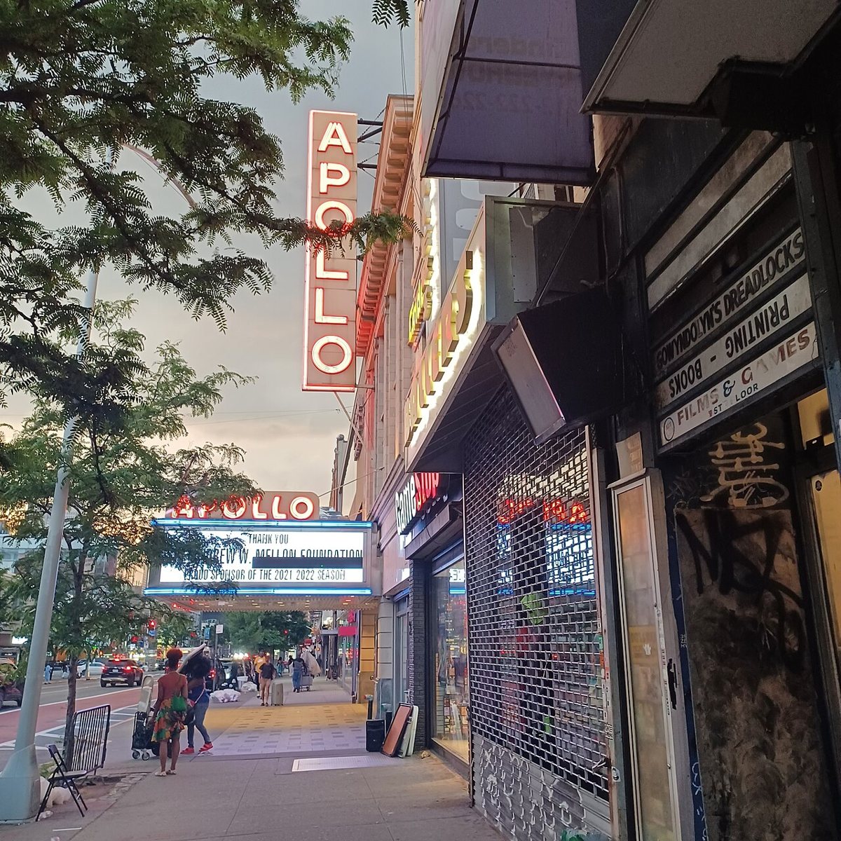 The Apollo Theater's iconic marquee sign on 125th Street in Harlem on a busy afternoon